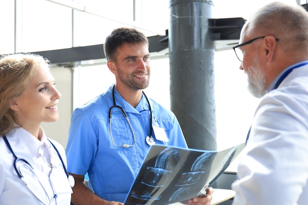 Gruppe von Ärzten, die Röntgenstrahlen in einem Krankenhaus überprüfen.