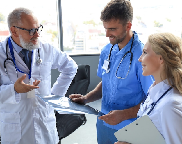 Gruppe von Ärzten, die Röntgenstrahlen in einem Krankenhaus überprüfen.