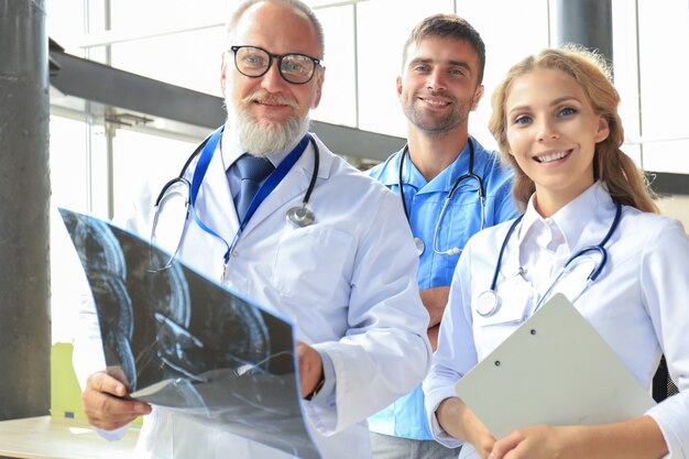 Gruppe von Ärzten, die Röntgenstrahlen in einem Krankenhaus überprüfen.