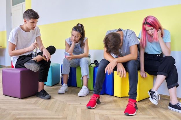 Gruppe von Schülern im Teenageralter in der Schule sitzen ruhend reden. Teenager, Freundschaft, Jugend, Schule, College-Konzept