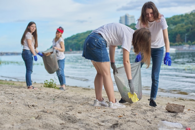 Gruppe von Schülern mit Lehrer in der Natur, die Plastikmüll reinigen. Umweltschutz, Jugend, Freiwilligenarbeit, Wohltätigkeit und Ökologiekonzept