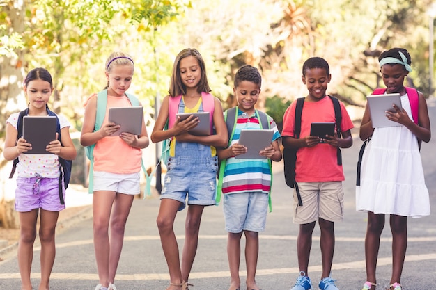 Gruppe von Schulkindern, die digitales Tablett verwenden