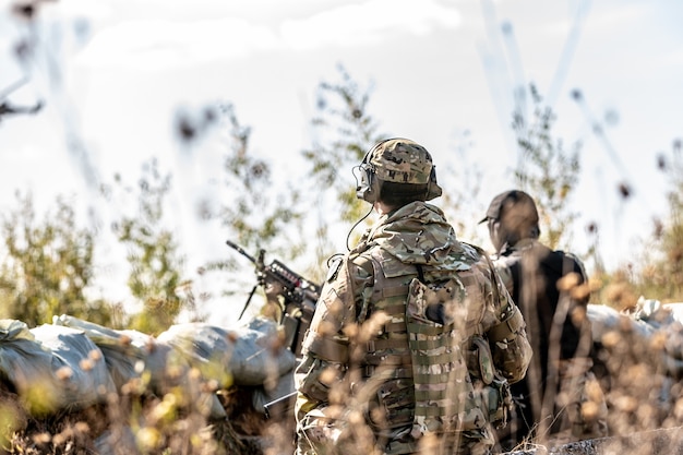 Gruppe von Soldaten im Freien auf Armeeübungen. Kriegs-, Armee-, Technologie- und Menschenkonzept