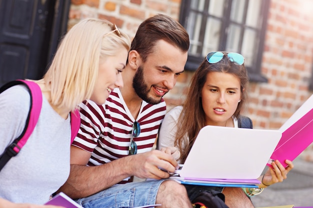 Gruppe von Studenten, die auf dem Campus sitzen