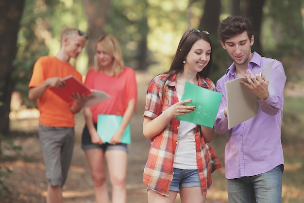 Gruppe von Studenten, die Prüfungsfragen diskutieren, die im Park stehen