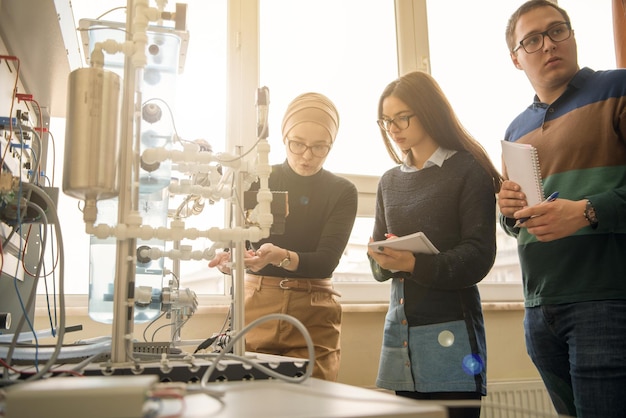 Gruppe von Studenten, die technische Berufspraxis mit jungen muslimischen Lehrerinnen im elektronischen Klassenzimmer, Bildungs- und Technologiekonzept machen