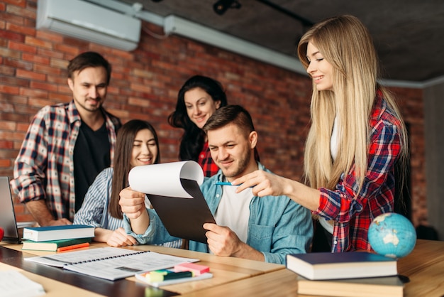 Gruppe von Studenten, die zusammen auf Laptop schauen