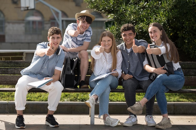 Gruppe von Teenager-Studenten, die ein Ok-Zeichen machen