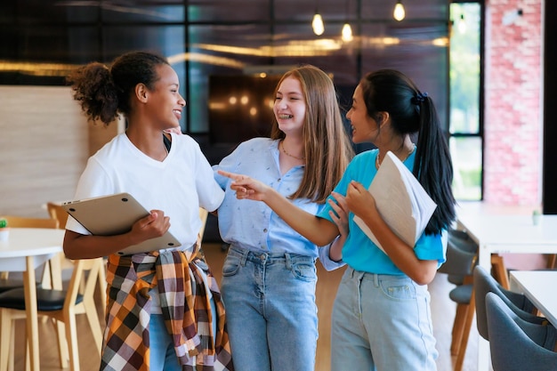 Gruppe von Teenager-Studenten, die zum Anlehnen in der Bibliothek der Schule gehen Universitätsbibliotheksbildung und Lernkonzept für Studenten