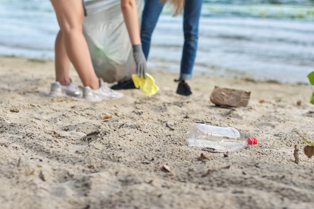 Gruppe von Teenagern am Flussufer, die Plastikmüll in Säcken aufsammeln. Umweltschutz, Jugend, Freiwilligenarbeit, Wohltätigkeit und Ökologiekonzept