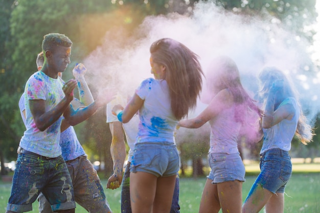 Gruppe von Teenagern, die mit Farben am Holi-Festival in einem Park spielen