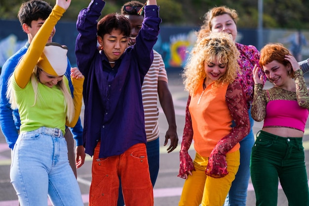 Foto gruppe von teenagern verschiedener ethnien in bunten kleidern, die zusammen tanzen