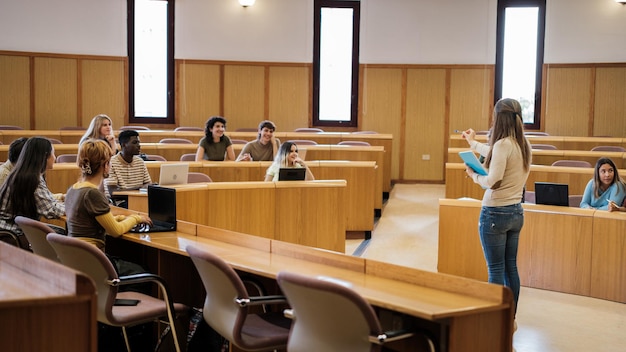 Gruppe von Universitätsstudenten in einem kreisförmigen Klassenzimmer, die sich mit den Erklärungen des multikulturellen und wissenschaftlichen Konzepts der Lehrerbildung befassen