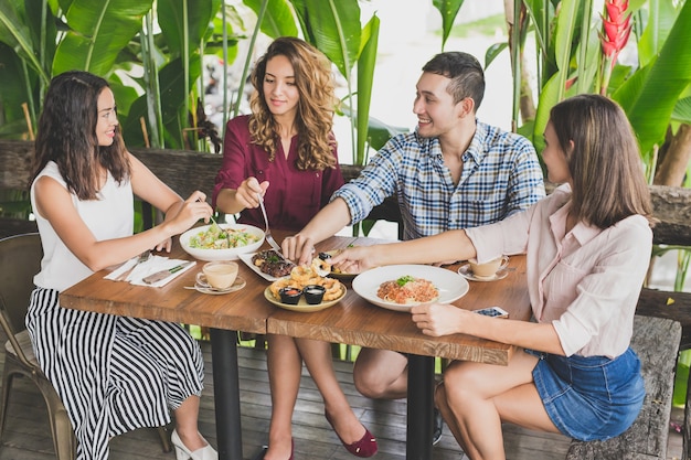 Gruppe von vier besten Freunden, die zusammen in einem Café zu Mittag essen