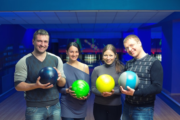 Gruppe von vier Freunden in einer Bowlingbahn, die Spaß hat