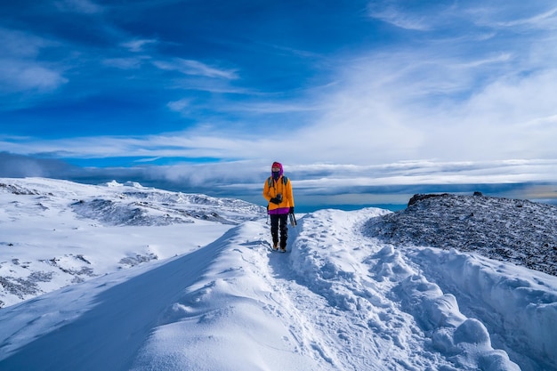 Gruppe von Wanderern, die zwischen Schnee und Felsen des Kilimanjaro-Berges wandern