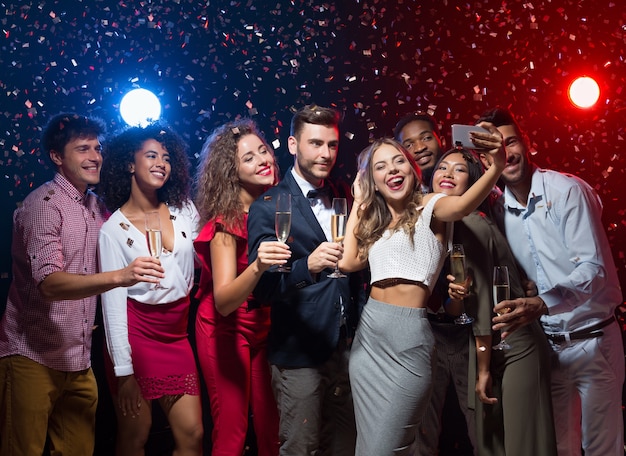 Gruppen-Selfie im Urlaub. Junge Freunde, die sich auf der Silvesterparty amüsieren und Fotos machen, Platz kopieren