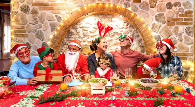 Gruppenfoto der glücklichen Familie mit Weihnachtsmützen, die Spaß an der Weihnachtsfest-Hausparty haben