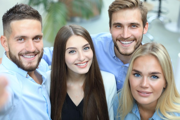 Gruppenfoto von Kollegen, die sich in ihrem Büro amüsieren.