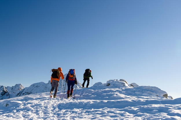 Gruppenwanderer in der schönen Landschaft der Winterberge und im blauen Himmel