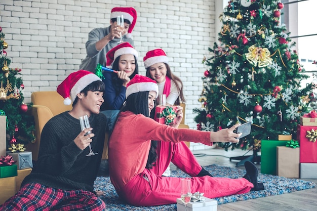 Gruppieren Sie junge Asiaten mit dem Feiern von Weihnachtsfest und Selfie nach Hause.