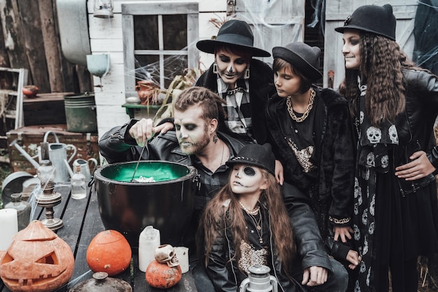 Foto gruselige familie, mutter, vater, töchter, die halloween feiern. hexenkessel