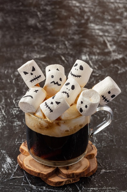 Gruselige Gesichter (Monster) von Marshmallows in einer Tasse Kaffee für Halloween