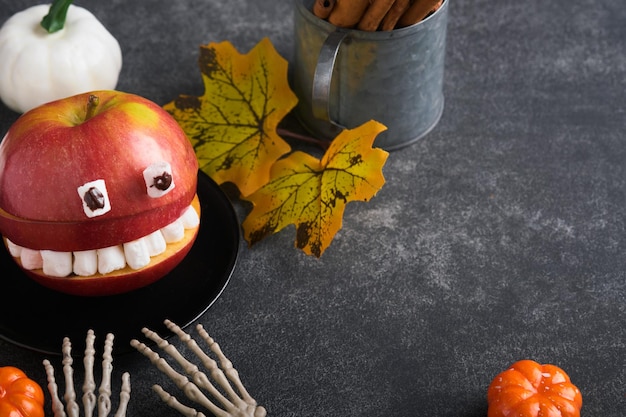 Gruselige grüne Kiwi-Monster für Halloween Gesunde Früchte Halloween-Leckereien Halloween-Party-Kiwi-Erdbeerapfel und Marshmallow-Monster auf dunkelgrauem Stein- oder Betontischhintergrund