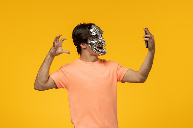 Gruselige Maske, erschreckender süßer Typ, der ein gruseliges Selfie mit der Maske macht