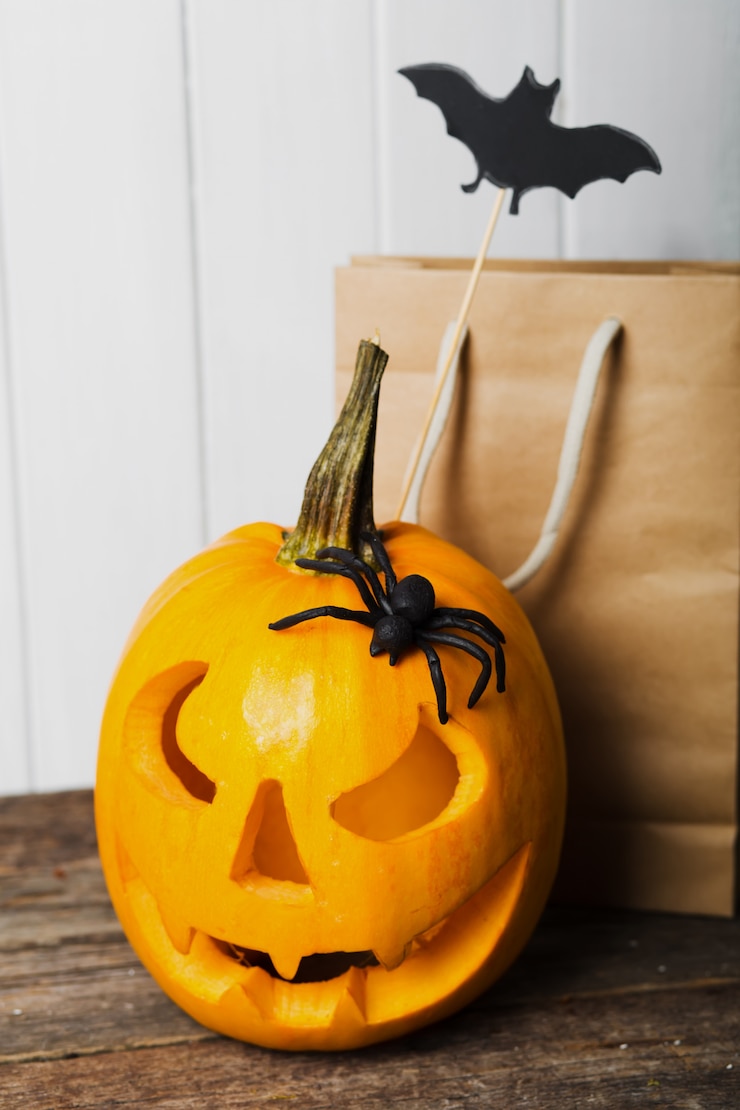 Foto gruseliger halloween-kürbis mit fledermäusen auf weiß.