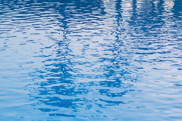 Água azul com ondas na piscina de manhã.