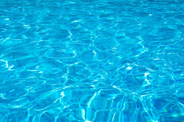 Água azul da piscina com reflexos do sol