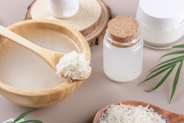 Água de arroz cosmética caseira com ingredientes e kit de beleza em fundo bege