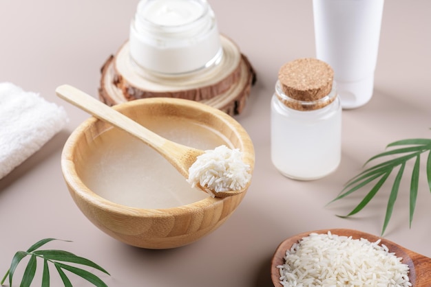 Água de arroz cosmética caseira com ingredientes e kit de beleza em fundo bege