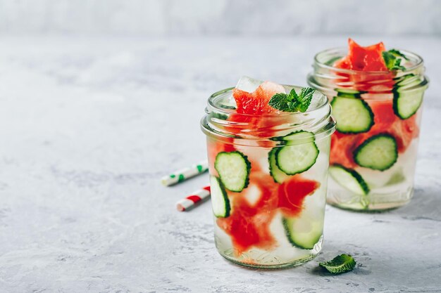 Água de desintoxicação infundida com fatias de pepino melancia e hortelã Cocktail de verão gelado ou limonada em frasco de vidro