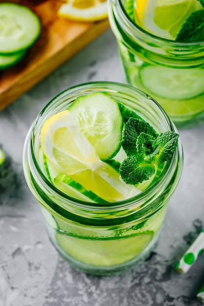 Água de desintoxicação infundida com pepino, limão e limão Refrescante coquetel de verão gelado ou limonada em frasco de vidro