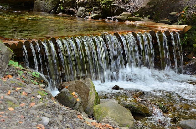 Água de madeira artesanal drena de pequenas vigas tratadas