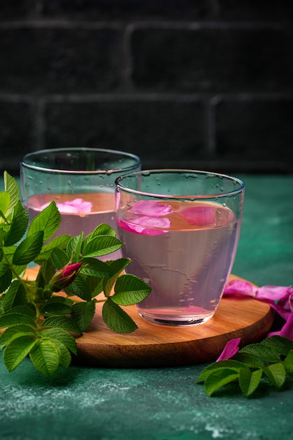 Água de rosas cor de rosa com pétalas e folhas