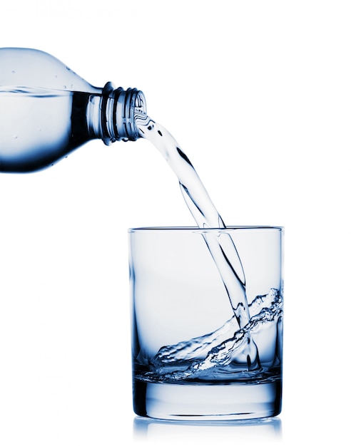 Água derramando em copo grande de garrafa