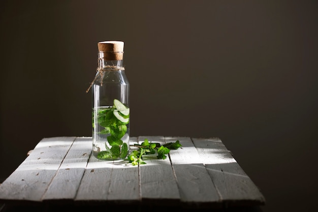 Água desintoxicante nutritiva ou limonada com pepino e hortelã na mesa de madeira