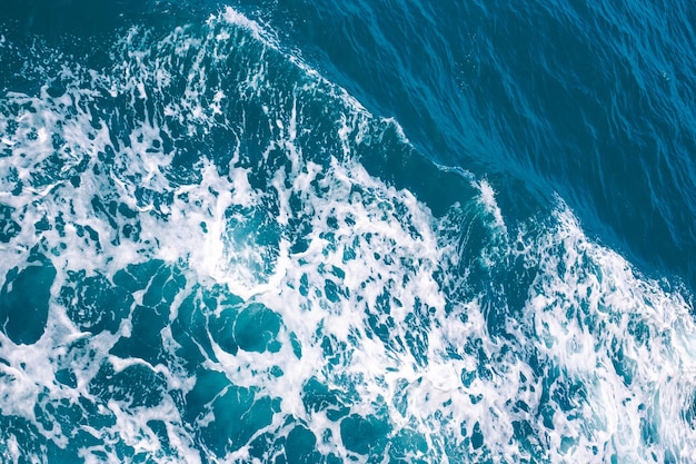 Água do mar azul com ondas e vista superior de espuma Fundo da superfície da água