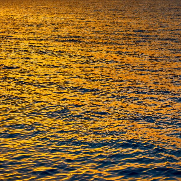 Água do mar dourada ao pôr do sol pode ser usada como pano de fundo