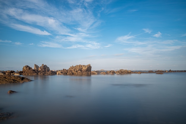 Água do mar e recifes à beira-mar sob o céu azul