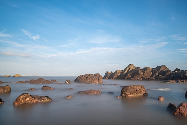 Água do mar e recifes à beira-mar sob o céu azul