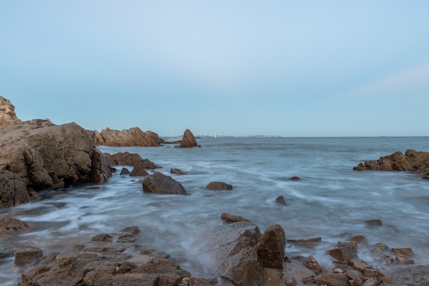 Água do mar e recifes à beira-mar sob o céu azul