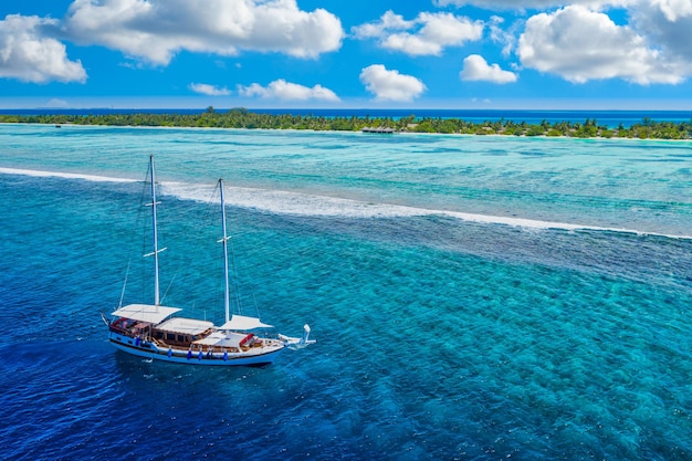 Água do mar turquesa bonita com barco. Recife de corais tropical sobre foto aérea vista, lagoa oceânica