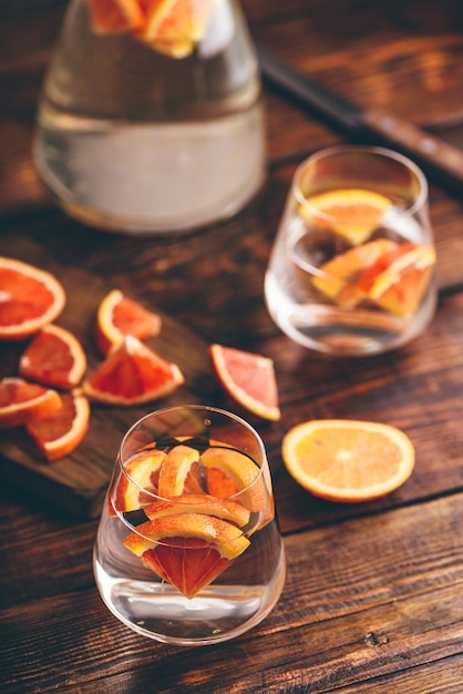 Água infundida com laranjas vermelhas em copo