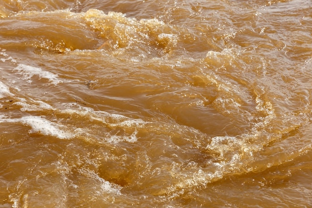 Água lamacenta do rio água lamacenta suja com banheira de hidromassagem e espuma branca fechada