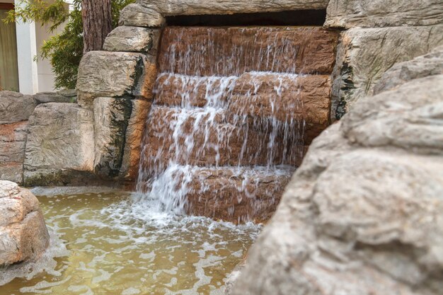 Água limpa flui através de uma cachoeira artificial