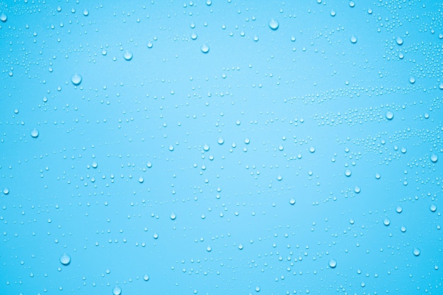 Água ou gotas de chuva em folha de plástico azul